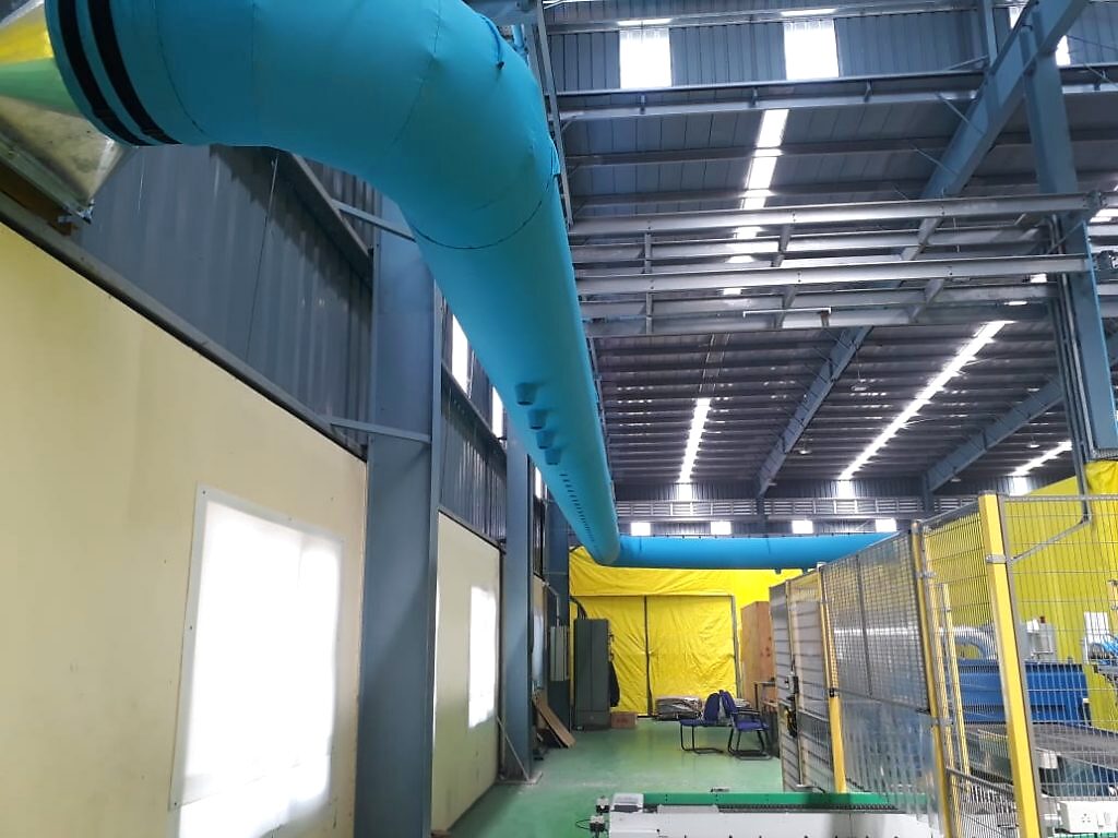 A blue fabric duct running the length of a large industrial warehouse